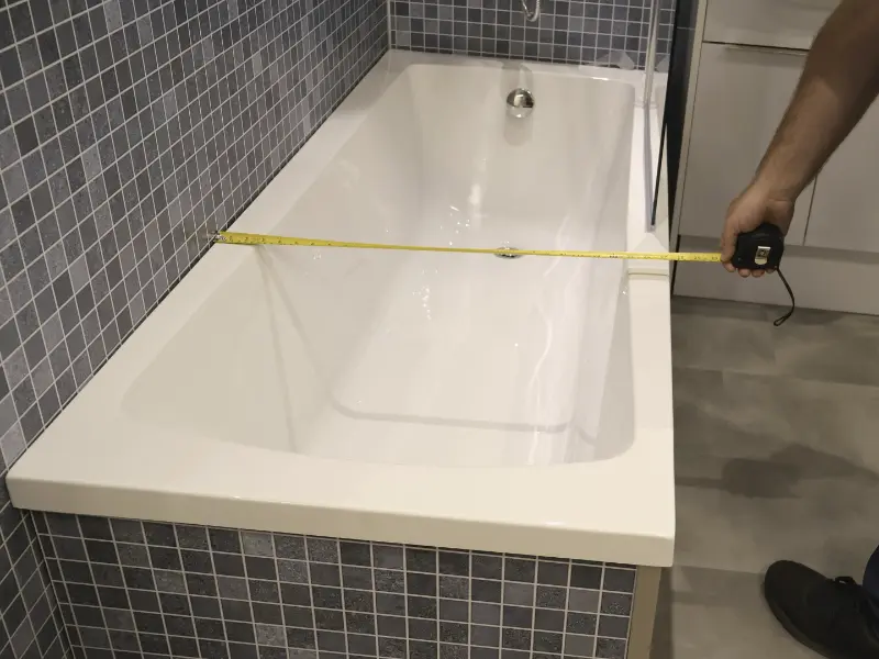 Person measuring bathtub dimensions